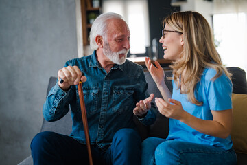 Happy Grandfather and Adult Granddaughter Enjoying Conversation at Home