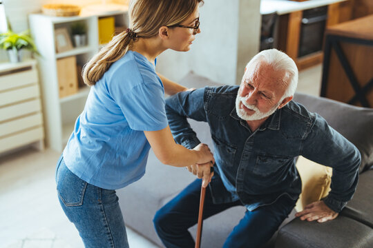 Young Caregiver Assisting Senior Man with Mobility at Home