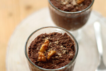 Two bowls of chia seed, chocolate and orange pudding. Healthy snack, wooden background. Selective focus.