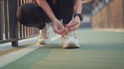 Close up - Running shoes runner woman tying laces sneakers for summer run in the city. Jogging girl exercise motivation health and fitness exercise, lifestyle.