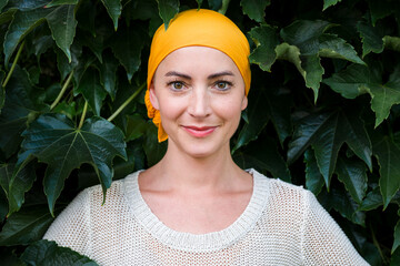 Beautiful young positive female cancer patient wearing headsacrf, looking and smiling at the camera...