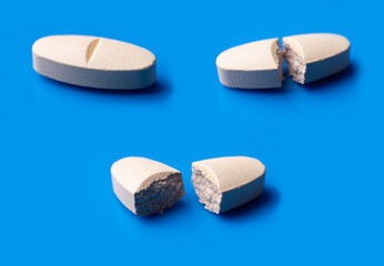 White broken pills lie on a blue background.Pharmacy medicament concept.