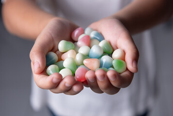 Multicolored candies in the hands of a child