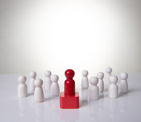 Leadership concept - red wooden figure leading other wooden figures reaching. Leadership concept