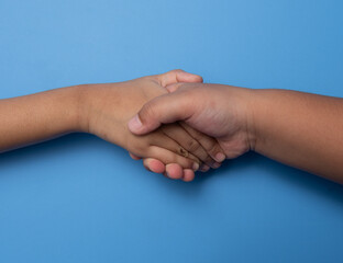 Two people is handshake isolated on a blue background, teamwork, partnership deals, business cooperation.