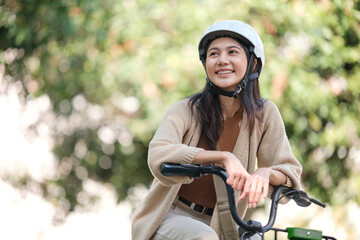 Obraz premium A woman is sitting on a bicycle wearing a helmet