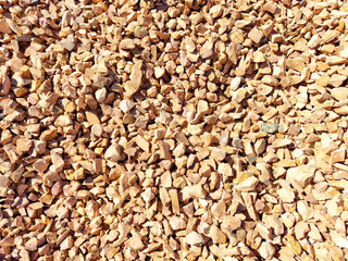 Small, colorful gravel stones cover the ground at construction location under clear blue skies. background, texture, pattern, frame, place for text