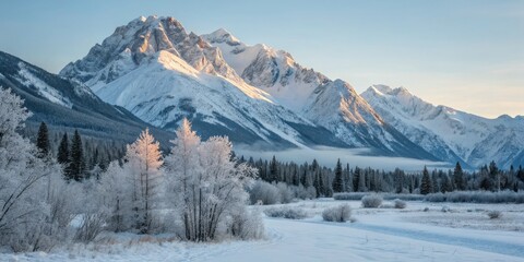 Obraz premium Majestic Snow-Covered Mountains Tower Against a Pale Blue Sky in a Serene Winter Landscape Scene