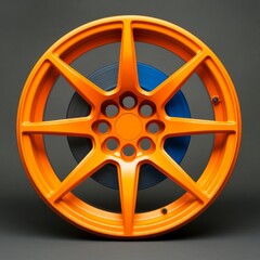 Obraz premium A vibrant orange car wheel with a blue inner rim, showcasing modern design.