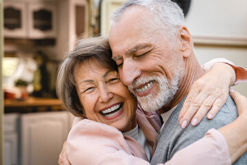 Cheerful caucasian senior old elderly couple spouses husband and wife hugging bonding embracing