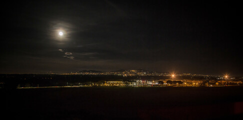 Fototapeta premium Summer full moon with the lights of the Castelli Romani in background