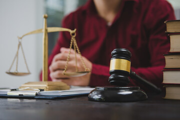 An Asian male lawyer meticulously reviews legal documents, ensuring accuracy and compliance for an upcoming court case. He highlights key points and prepares strategies to effectively