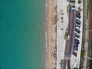 A photo of a beach with a train on the tracks