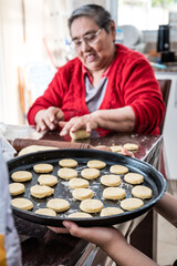 abuela alegre, amasando galletas con la ayuda de sus nietas 