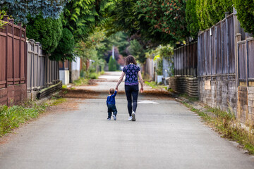 Mother and Child Walking in Peaceful Neighborhood Street