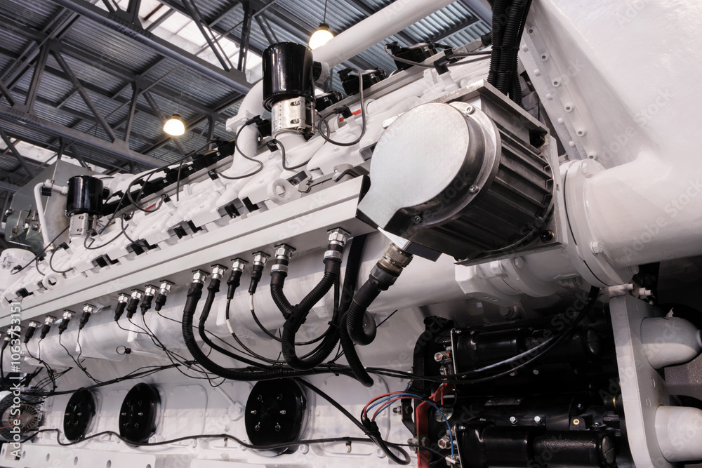 Poster A large engine with many parts is shown in a factory. The engine is made of metal and has a lot of pipes and valves. Concept of industrialization and the complexity of machinery