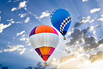Colorful hot air balloon flying over blue sky with white clouds	