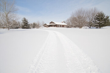 Obraz premium A snow covered road leading to a house