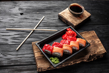 Dark Plate Sushi Presentation with Dipping Sauces