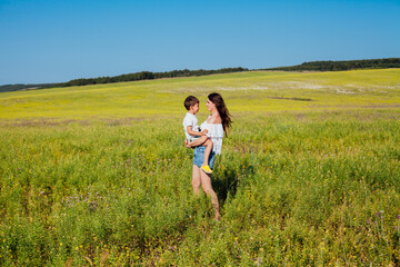 Mother and son on a walk in a rural road by the field