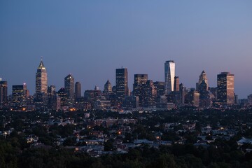 Obraz premium Majestic Evening Skyline of Urban Metropolis with Radiant City Lights and Suburban Serenity