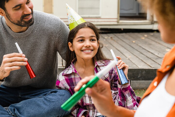 Closeup cropped shot of happy family of three parents and mixed-race daughter celebrating birthday...