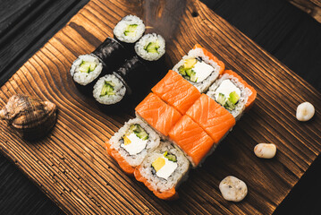 Variety of Sushi Rolls with Chopsticks on Black Board