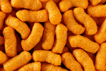 Background of crunchy corn snacks close-up, top view, background of air corn sticks