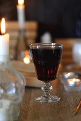 Books, lit candles, red wine, snacks and various deocration on the table. Dark academia or Halloween concept. Selective focus.