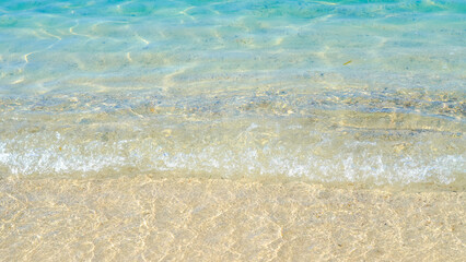 Turquoise sea background with gentle waves and bright sunlight reflections.