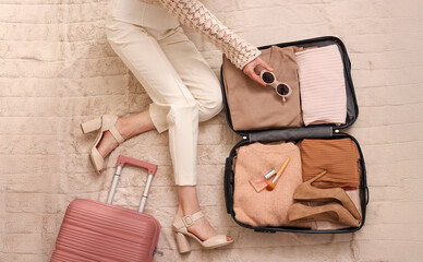 Suitcase with women's clothes and accessories. girl packing for a trip. The concept of vacation and travel.