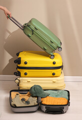 Prepare accessories and travel items with a map on the floor of the suitcase, a woman's hand holding a travel bag