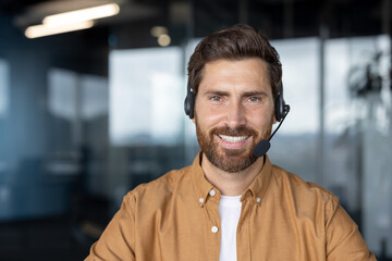 Mature business man smiling in a modern office while wearing a headset. Professional demeanor...