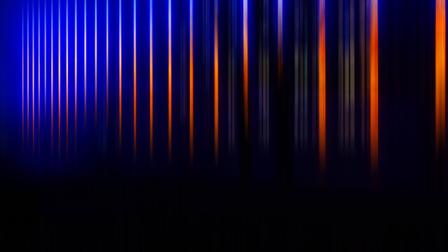 Abstract blurred background - vertical parallel color stripes orange, light, blue on black.