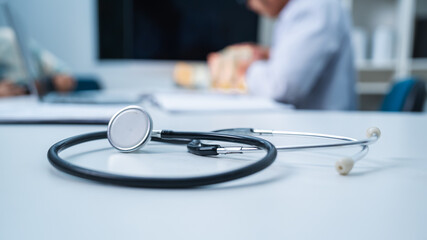 A close up of stethoscope on a doctor's table in hospital office, concept of hospital background or health care, diagnosis or treatment wallpaper.