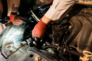 Obraz premium Mechanics Performing Car Engine Repair at Night