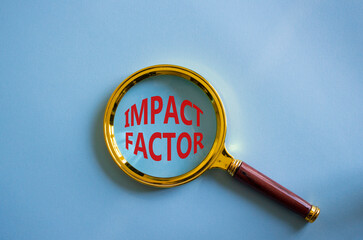 Impact Factor symbol. Magnifying glass with words Impact Factor. Beautiful blue background. Business and Impact Factor concept. Copy space.