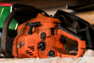 Fototapeta premium Vintage Chainsaw Resting on a Workbench Amidst Tool Surroundings