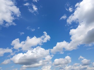 Fototapeta premium Clear blue sky filled with fluffy white clouds, creating a peaceful and serene atmosphere, background, fluffy
