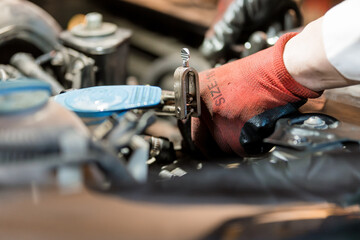 Mechanic Repairing Engine with Tools in Automotive Workshop