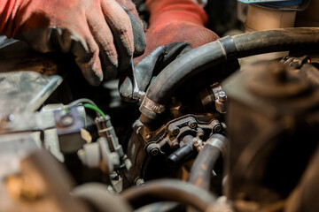 Close-Up of a Mechanic Repairing an Engine Component with Protective Gloves