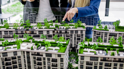 A real estate agent advises a client on the purchase of an apartment in a modern office modeled...
