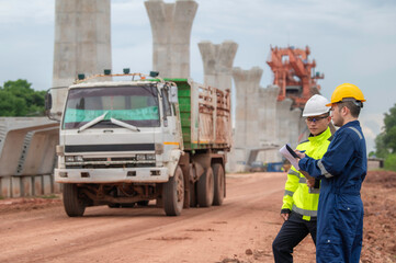 An Asian male engineer works at a motorway bridge construction site,Civil worker inspecting work on crossing construction,Supervisor working at high-speed railway construction site