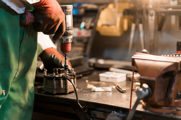 Skilled Mechanic Using Power Drill in Workshop for Equipment Repair