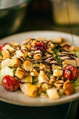 Colorful salad with mixed greens, cherry tomatoes, and balsamic drizzle. Perfect for healthy lifestyle campaigns or menus, showcasing fresh ingredients and vibrant colors.