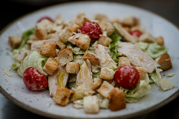 Fresh Caesar salad with cherry tomatoes, croutons, and shaved parmesan. Excellent for menus and healthy dining promotions, capturing the fresh, classic Caesar look.