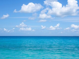 A beautiful photo of a calm ocean background with clear blue water and fluffy white clouds in the sky, peaceful, relaxation