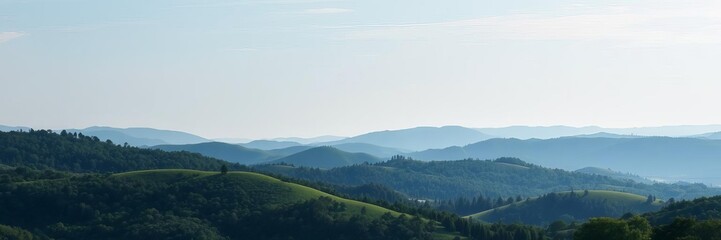 Fototapeta premium A beautiful landscape of rolling hills covered in lush green trees under a clear blue sky, scenery, blue