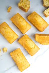 Close-up of corn muffins on plate with bowl of corn meal and additional muffins in the background.