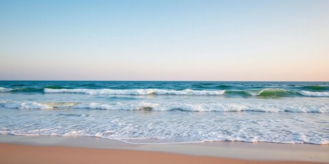 Obraz premium A serene ocean background with calm waves gently rolling onto a sandy beach under a clear blue sky, sea, background